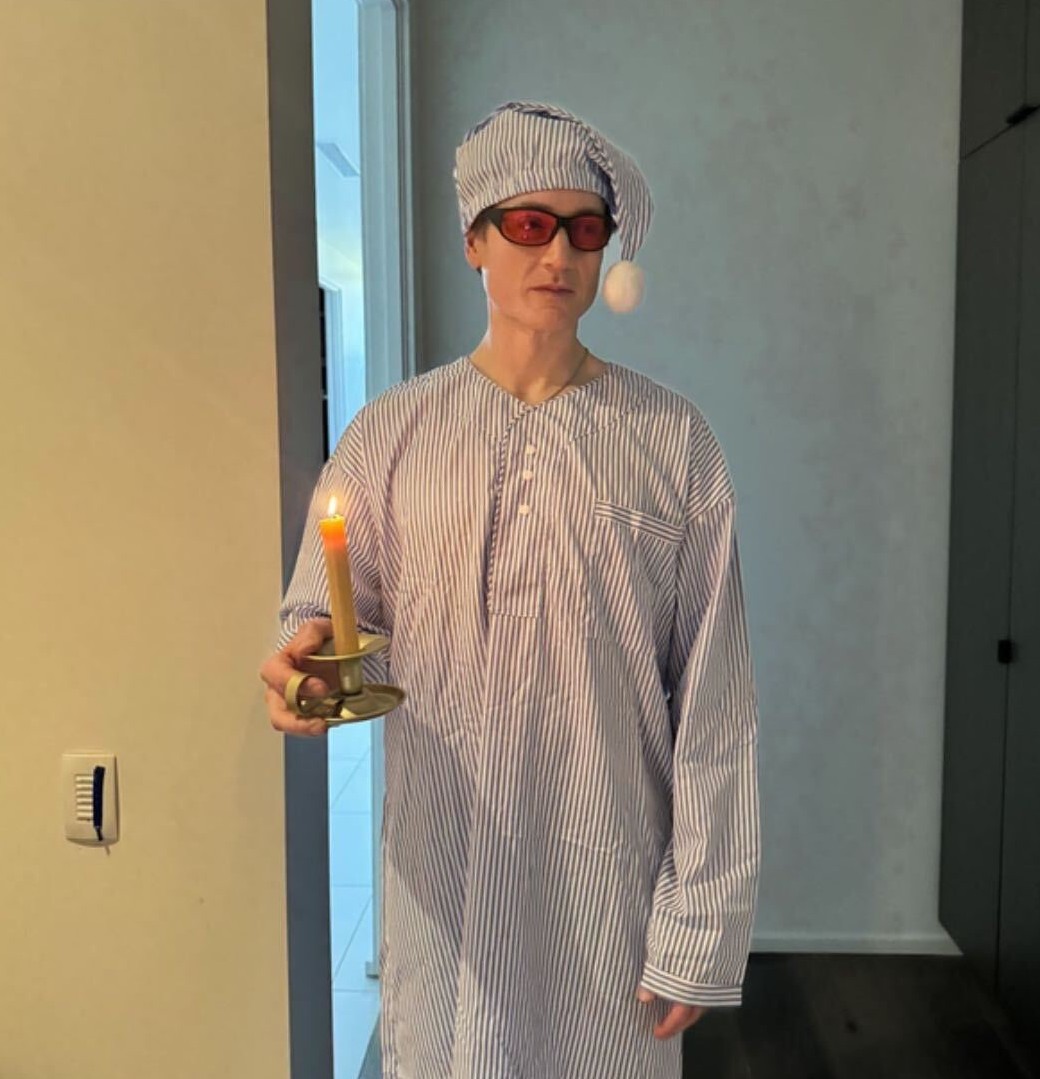 Person in pajamas holding a candle